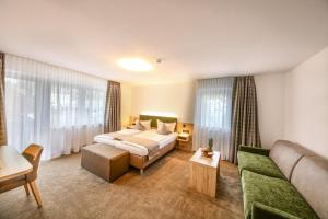 una camera d'albergo con letto e divano di Hotel Restaurant Schwörer a Lenzkirch