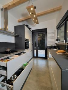 cocina grande con encimeras blancas y electrodomésticos de acero inoxidable en House Momentum, en Lovinac