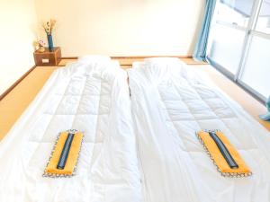 un letto bianco con due cuscini sopra di Fuyosankyoenka - Vacation STAY 98171v a Fujikawaguchiko