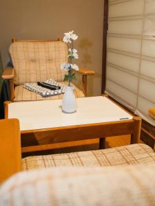 a vase of flowers on a table with a chair at Fuyosankyoenka - Vacation STAY 98171v in Fujikawaguchiko