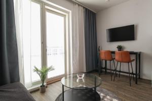 a living room with a glass table in front of a window at Pramea Apartments Aapelintupa in Kuopio