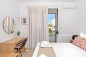 a bedroom with a bed and a desk and a mirror at Casa Kamara in Kounoupidhianá
