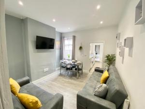 a living room with a couch and a dining room at Emerald Properties UK - Stoke-on-Trent City Centre, close to Alton Towers in Stoke on Trent