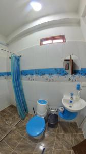 a bathroom with a blue toilet and a sink at Hostal Grand Park Palomino in Palomino