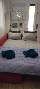 a bed with two blue pillows on top of it at Loft El pez blanco in El Puerto de Santa María