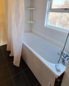 a bathroom with a bath tub with a window and a shower curtain at Хотел на Печерской in Kyiv