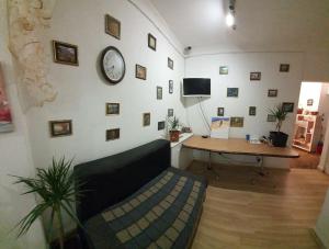 a living room with a couch and a clock on a wall at Хотел на Печерской in Kyiv