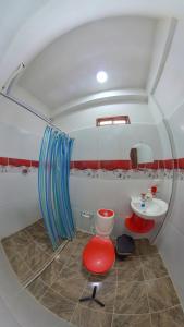 a bathroom with a sink and a toilet and a mirror at Hostal Grand Park Palomino in Palomino