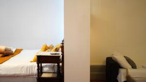 um quarto com uma cama com almofadas amarelas em Casa Borges em Coimbra