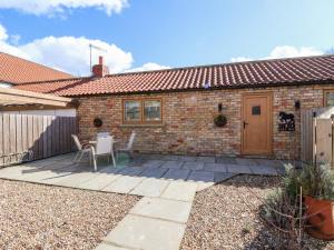 a patio with a table and chairs in front of a house at The Stables in Great Driffield