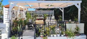 pérgola blanca con mesa, sillas y plantas en Diasoulas house en Rodas