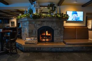 a fireplace in a restaurant with a tv above it at Knob Hill Inn in Ketchum