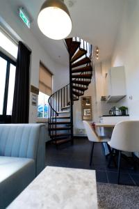 a living room with a spiral staircase and a kitchen at Plantage Garden Apartments in Amsterdam