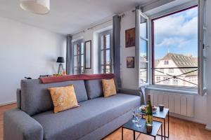 sala de estar con sofá y ventana grande en Le Batelier - Golden Tree - Centre historique - WIFI en Estrasburgo