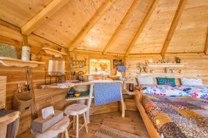 a log cabin bathroom with a sink and a bed at ARBORdomcek in Horná Lehota