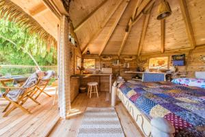 een slaapkamer in een blokhut met een bed en een keuken bij ARBORdomcek in Horná Lehota