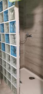 a shower with a wall of plastic bins in a bathroom at Warchały near Szczytno, RUSTIC LODGE at Lake in Narty