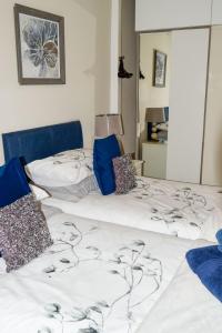 1 dormitorio con 2 camas con sábanas azules y blancas en Beval Cottage, en Abergavenny