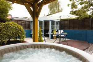 a water feature in a garden with a pergola at Beval Cottage in Abergavenny