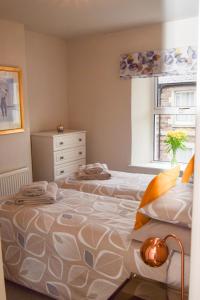 een slaapkamer met 2 bedden en een raam bij Beval Cottage in Abergavenny