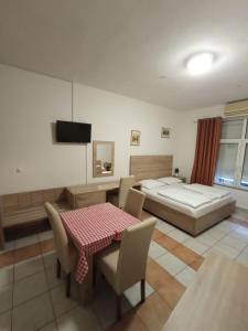 a bedroom with a bed and a table and chairs at Lovely Home Rooms & Apartments in Mostar