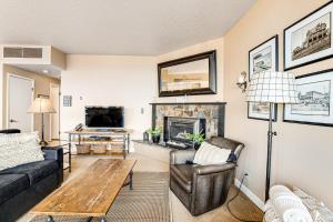 a living room with a couch and a table and a fireplace at Sand & Sea: Coastal Cove (518) in Seaside