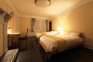 um quarto com 2 camas, uma secretária e uma janela em Waterhouse Memorial - Vacation STAY 14310 em Omihachiman