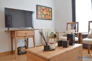 a living room with a tv on a wooden table at Apartamento La Maquina de Coser in Colombres