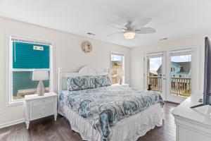 1 dormitorio con 1 cama y ventilador de techo en Sea Cloud, en Holden Beach