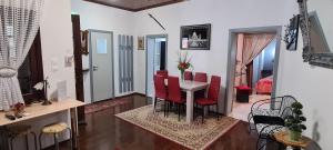 een woonkamer met een tafel en rode stoelen bij Diasoulas house in Rhodos-stad
