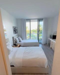 een slaapkamer met 2 bedden en een raam bij Amplio Studio en hotel Beachwalk Resort Miami in Hallandale Beach