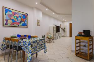 une salle à manger avec une table et un tableau mural dans l'établissement Next Door elegante villa a Bari, à Valenzano