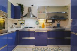 une cuisine avec armoires bleues et appareils en acier inoxydable dans l'établissement Next Door elegante villa a Bari, à Valenzano