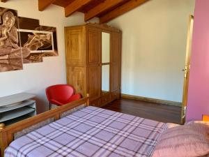萊薩卡的住宿－Chalet en Lesaka, cerca de San Sebastián，一间卧室配有一张床和一张红色椅子