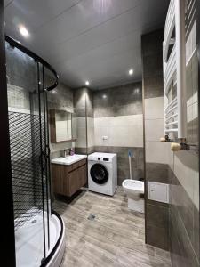uma casa de banho com uma máquina de lavar roupa e um WC em Apartment Merabi em Batumi