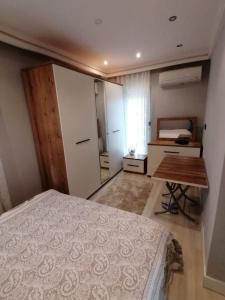 a bedroom with a bed and a desk in it at Holiday in Antalya