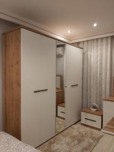 een slaapkamer met een grote witte kast met een spiegel bij Holiday in Antalya