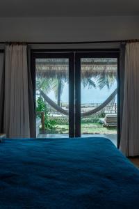 a bedroom with a bed with a view of the ocean at Hotel Boutique Zebra Beach in Uruau