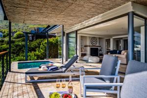 a patio with chairs and a table and a pool at Ocean's Horizon Beach House in Scarborough
