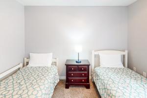 a bedroom with two beds and a table with a lamp at Cherry Valley Retreat in Gilford
