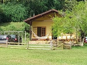 a small house with a hammock in front of it at Sitio Eco Friends - Perfeita para Casal e Família! in São Bento do Sapucaí