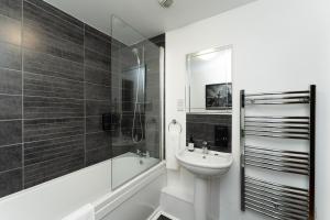 a bathroom with a sink and a bath tub and a toilet at High Street Town House in Manchester