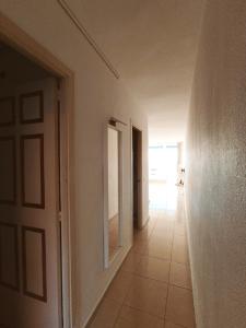 an empty hallway with a door and a tile floor at Piso primera línea en frente al mar in Santa Ponsa