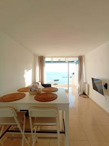 a room with a table and chairs with a view of the ocean at Piso primera línea en frente al mar in Santa Ponsa