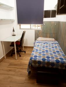 a room with a bed and a desk and a table and a desk at Precioso apartamento 3 habitaciones. Con patio. in Camas