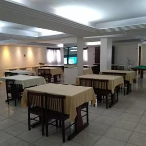 um restaurante com mesas e cadeiras com toalha de mesa amarela em Avalon Executive em Goiânia