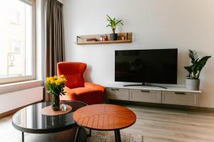 a living room with a television and a chair and a table at Apartament Środowa by Prestige Home in Szczecin
