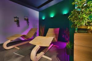 twee stoelen en een tafel in een kamer met paars en groen bij Room4stars in Otruševec