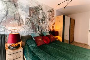sypialnia z zielonym łóżkiem i obrazem na ścianie w obiekcie Apartament Środowa by Prestige Home w Szczecinie