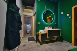 a bathroom with a green wall and a mirror at Room4stars in Otruševec